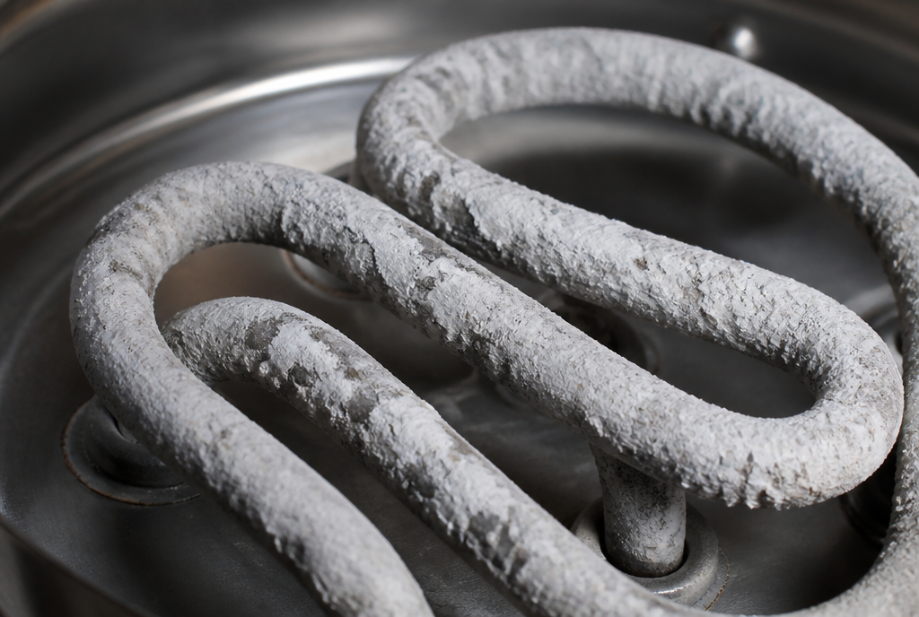 White limescale crust on metal heating elements from hard water