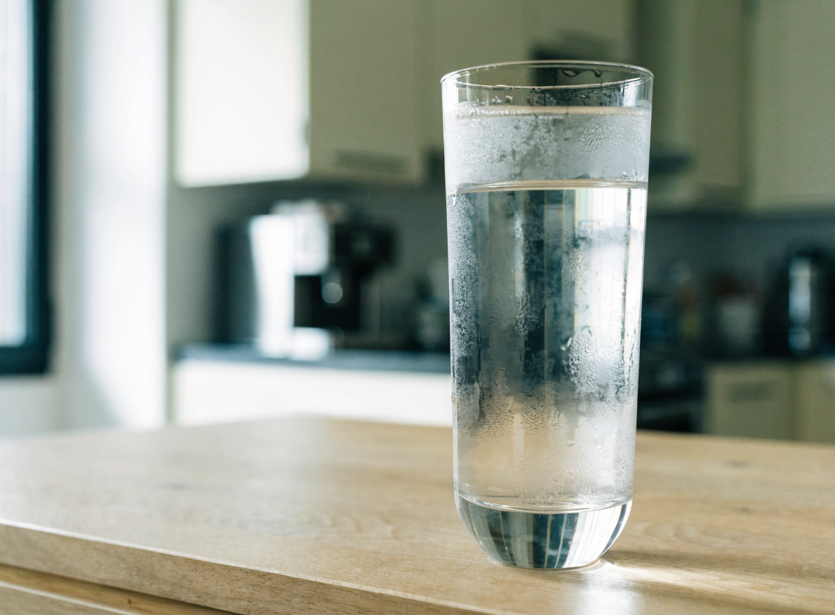 A glass of chilled clear drinking water on an office counter